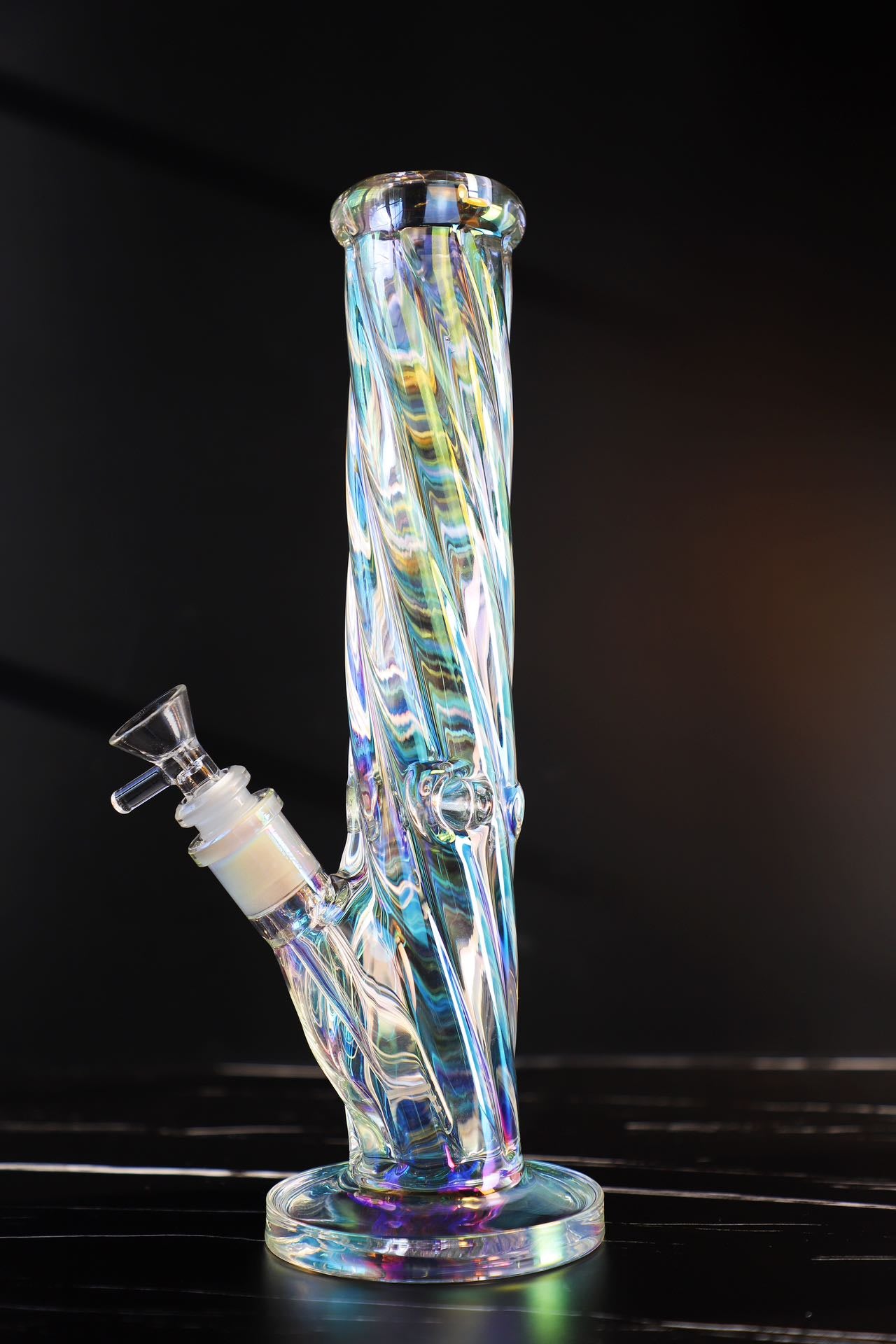 Experience a kaleidoscope of colors with this Thick, Iridescent Glass Bong. Its durable, high-quality borosilicate glass is sculpted into a Straight, Smooth-Hitting Water Pipe, an artistic smoking accessory offering both beauty and functionality. Its sleek design ensures stability for a premium, smooth hit every time. The color-changing, iridescent finish captivates with a symphony of hues, making it a unique and durable waterpipe for any collection.420