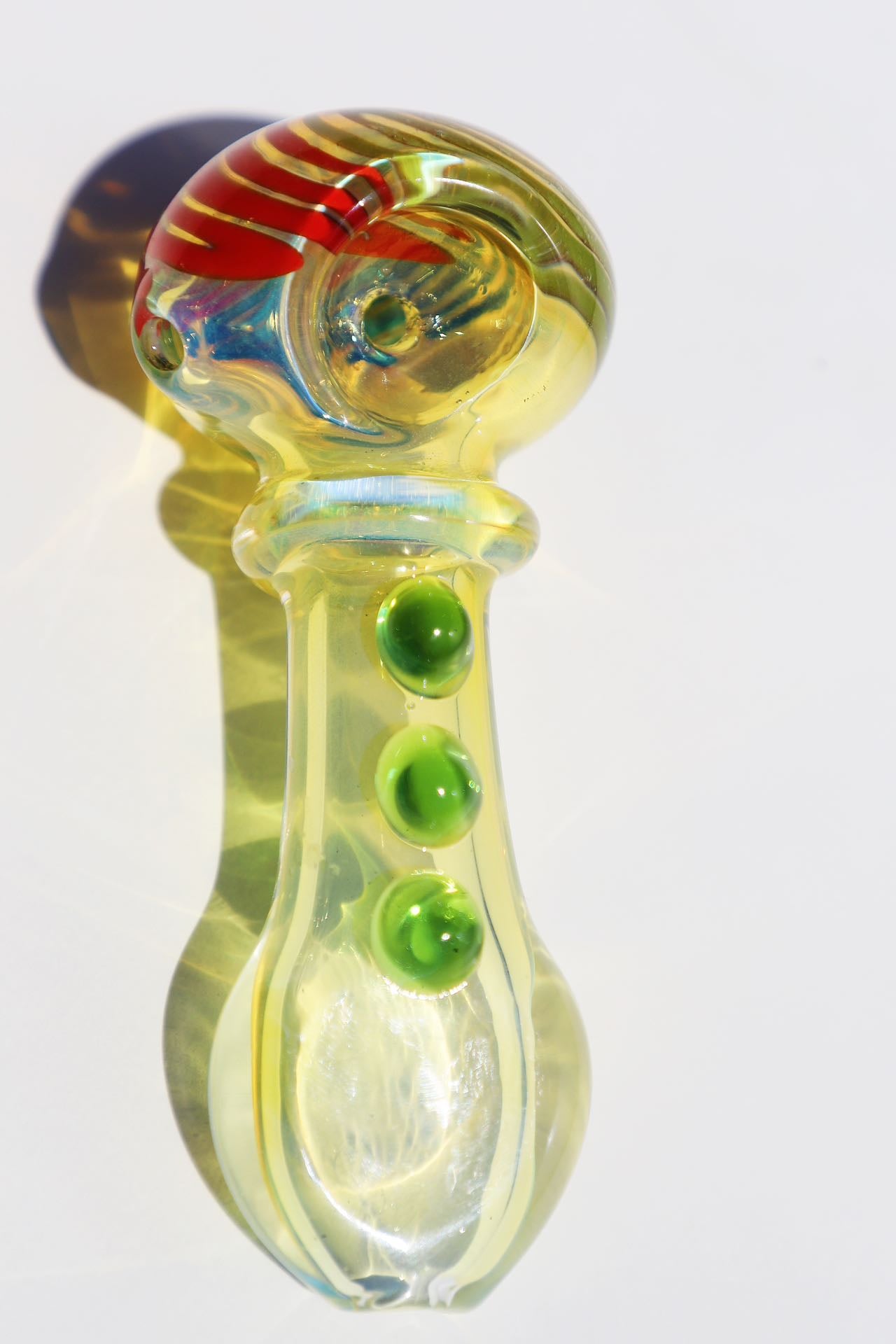 mmerse yourself in the radiance of our Handcrafted Sunburst Yellow Glass Smoking Pipe, featuring vibrant green bubble accents for a tactile experience. This artisanal handblown piece stands out with its unique spiral design, providing both aesthetic pleasure and functional smoking elegance. A perfect match for connoisseurs looking for a pipe that marries artistic craftsmanship with a splash of color for a joyful smoking session.