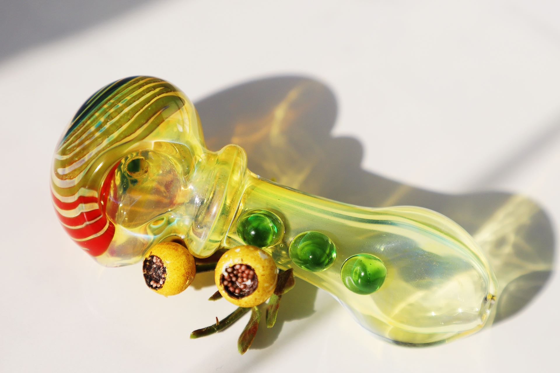 mmerse yourself in the radiance of our Handcrafted Sunburst Yellow Glass Smoking Pipe, featuring vibrant green bubble accents for a tactile experience. This artisanal handblown piece stands out with its unique spiral design, providing both aesthetic pleasure and functional smoking elegance. A perfect match for connoisseurs looking for a pipe that marries artistic craftsmanship with a splash of color for a joyful smoking session.