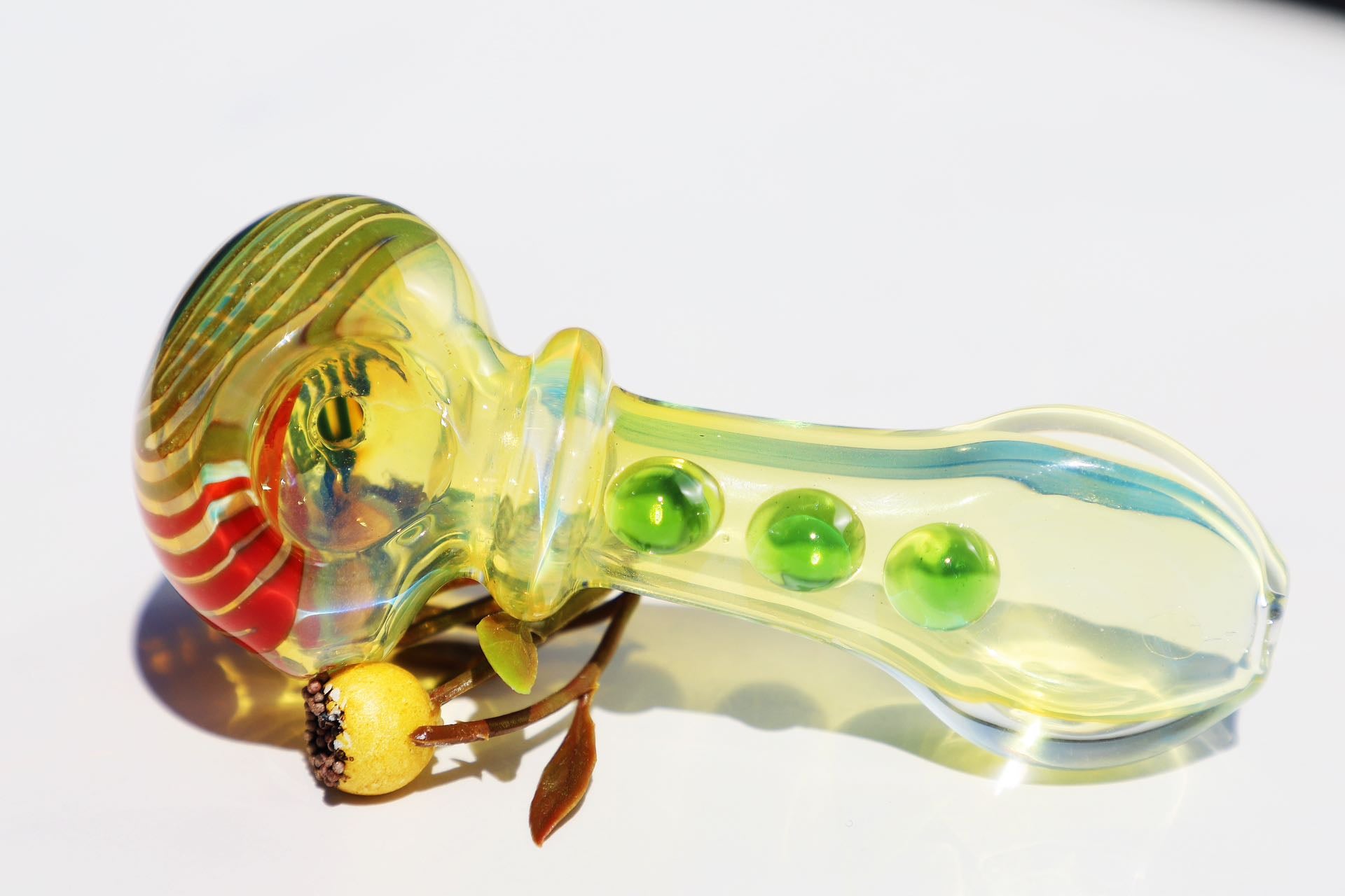 mmerse yourself in the radiance of our Handcrafted Sunburst Yellow Glass Smoking Pipe, featuring vibrant green bubble accents for a tactile experience. This artisanal handblown piece stands out with its unique spiral design, providing both aesthetic pleasure and functional smoking elegance. A perfect match for connoisseurs looking for a pipe that marries artistic craftsmanship with a splash of color for a joyful smoking session.