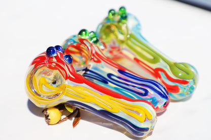 Handcrafted Vibrant Artisan Smoking Pipe, with rich swirls of sunburst yellow, deep blue, and ruby red glass. This compact, durable piece offers a uniquely artistic touch to your smoking ritual, blending bold colors and a functional design for a joyful experience.