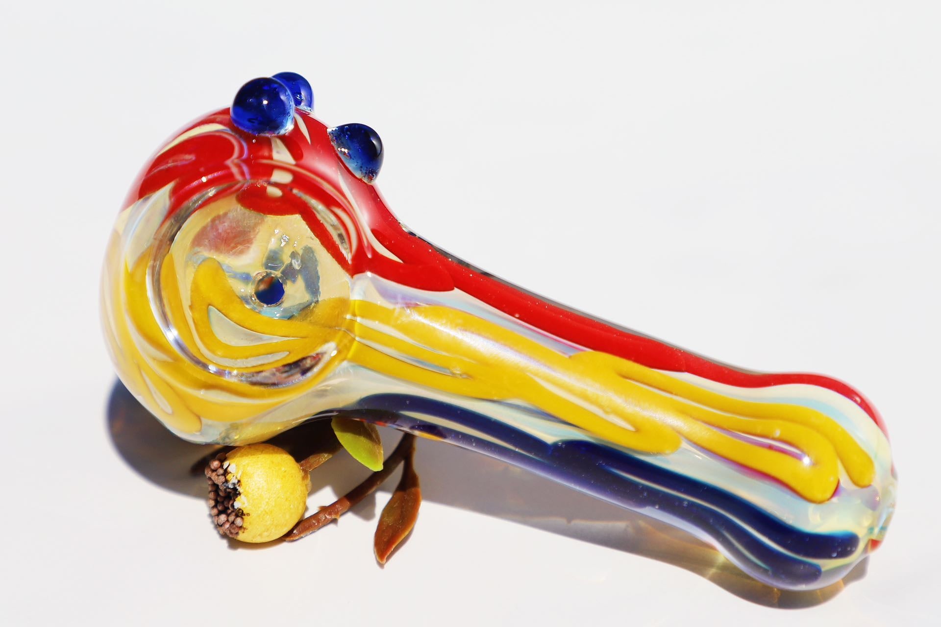 Handcrafted Vibrant Artisan Smoking Pipe, with rich swirls of sunburst yellow, deep blue, and ruby red glass. This compact, durable piece offers a uniquely artistic touch to your smoking ritual, blending bold colors and a functional design for a joyful experience.