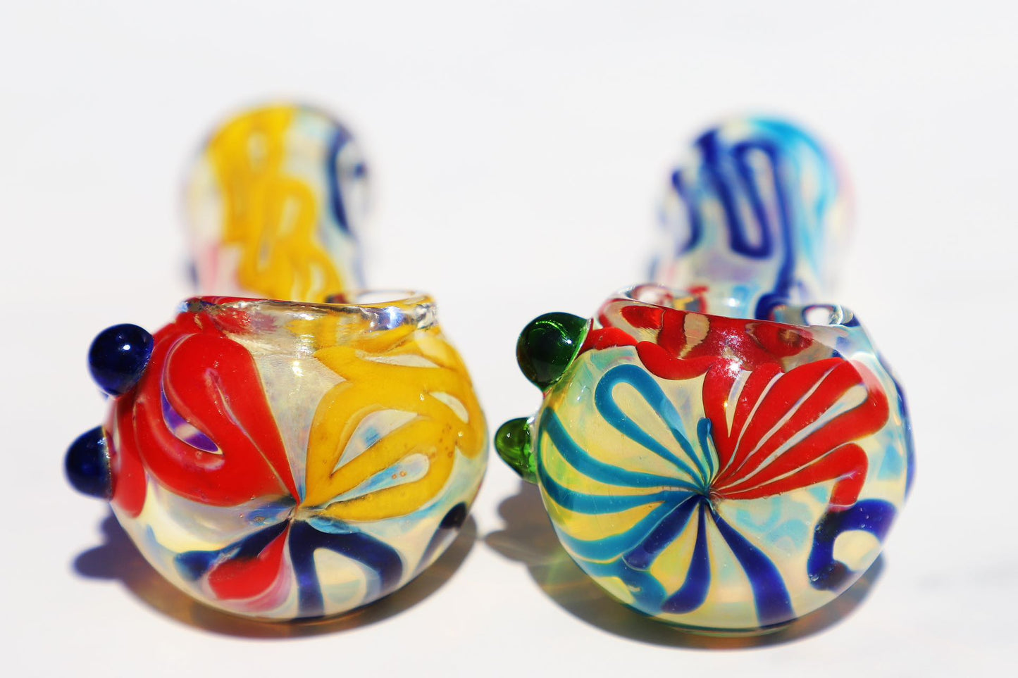 Handcrafted Vibrant Artisan Smoking Pipe, with rich swirls of sunburst yellow, deep blue, and ruby red glass. This compact, durable piece offers a uniquely artistic touch to your smoking ritual, blending bold colors and a functional design for a joyful experience.